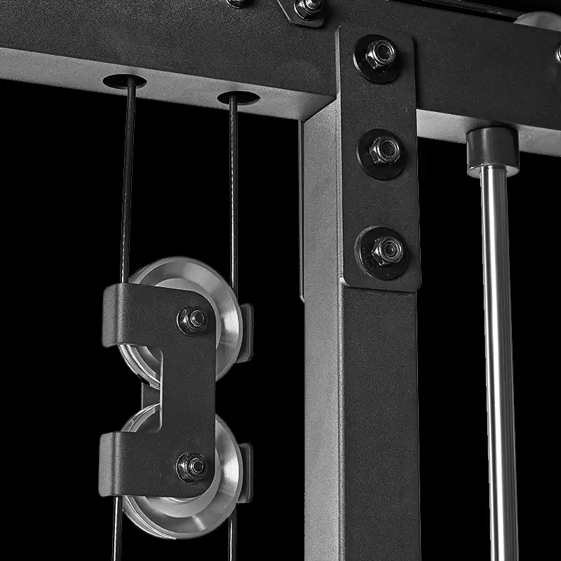 Close-up of the ATX® Triplex Weight Stack Gym’s metal pulley system, featuring two cables running through double wheels on a sturdy black frame against a black background.