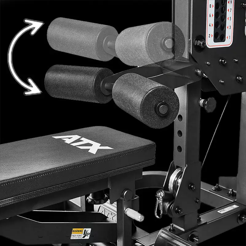 Close-up of the ATX® Triplex Weight Stack Gym featuring a padded bench and adjustable foam rollers, with arrows highlighting leg exercise movements. The black background enhances the gym’s design details.