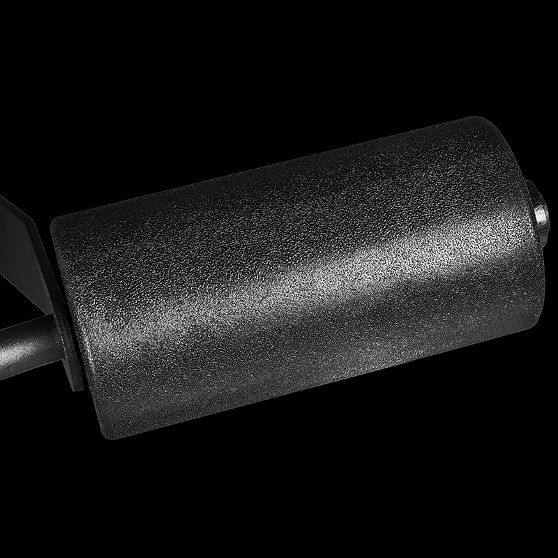 Close-up of a textured black foam roller attached to a metal bar on the ATX® Triplex Weight Stack Gym, isolated against a black background.