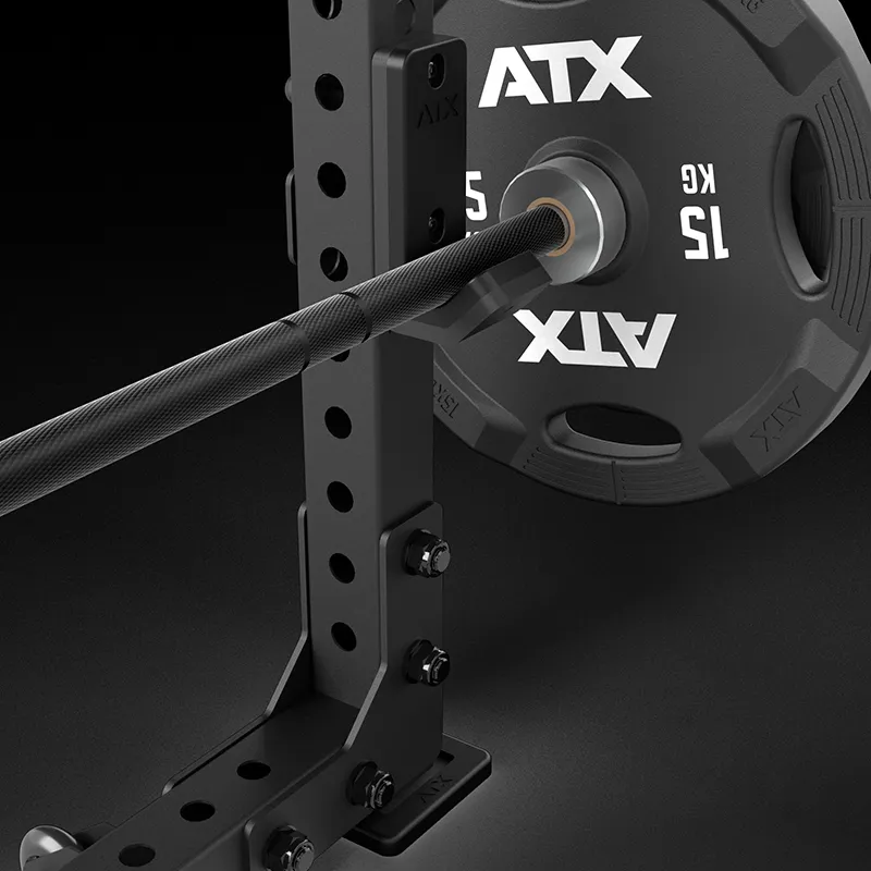 A close-up of a black 15 kg ATX weight plate on a barbell resting on the ATX® Seal Row Bench, with bolts and adjustment holes visible on the bench.