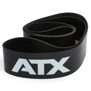 An ATX® Latex Free Resistance Band, featuring a coiled black design with "ATX" printed in white on the side, is rolled and resting on a white surface. It's perfect for enhancing your training routine.