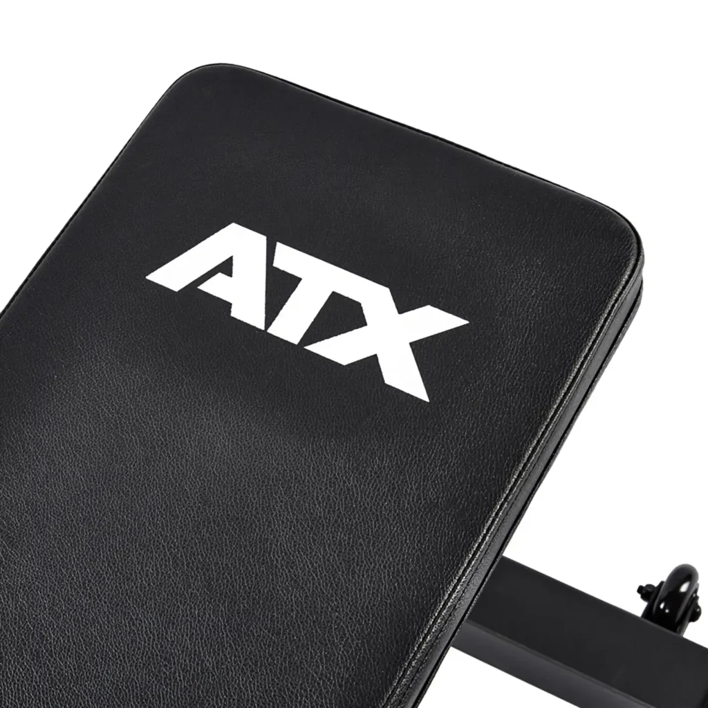 Close-up of a black flat weight lifting bench with ATX® on the cushion. The ATX® Flat Workout Bench Attachment is designed for strength training, featuring cushioned, durable materials for optimal support.