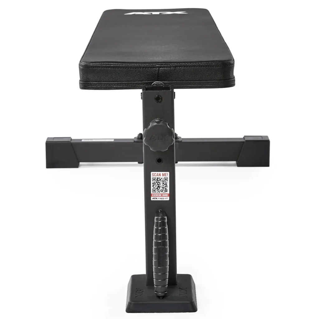 The ATX® Flat Workout Bench Attachment is a black bench with a padded surface and sturdy metal frame, featuring a QR code on the front support and a convenient handle at the base.