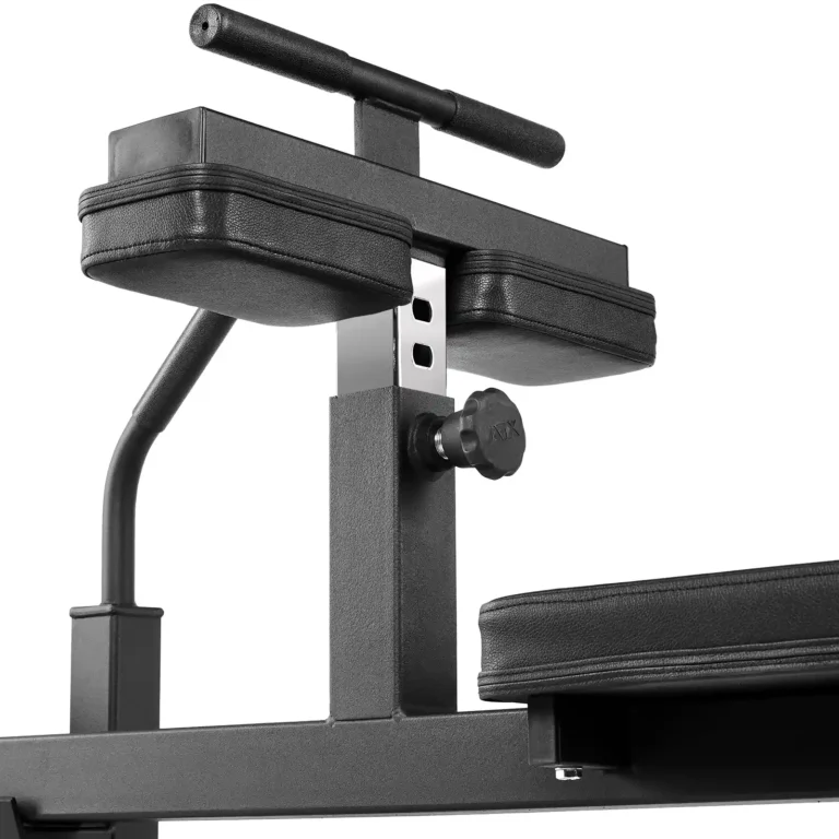 Close-up of black gym equipment featuring adjustable padded arm rests and a support bar. This ATX apparatus includes a knob for height adjustment and a padded seat, designed for exercises like dips or leg raises, similar in functionality to a sitting calf raise machine.