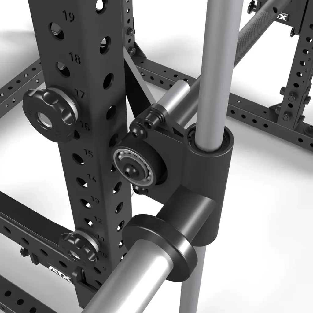 Close-up of the ATX® Smith Machine Bar Attachment - PRX-780, featuring a pivoting mechanism, numbered adjustment holes, and a metallic surface that reflects light from the sturdy crossbar, highlighting its robust construction.