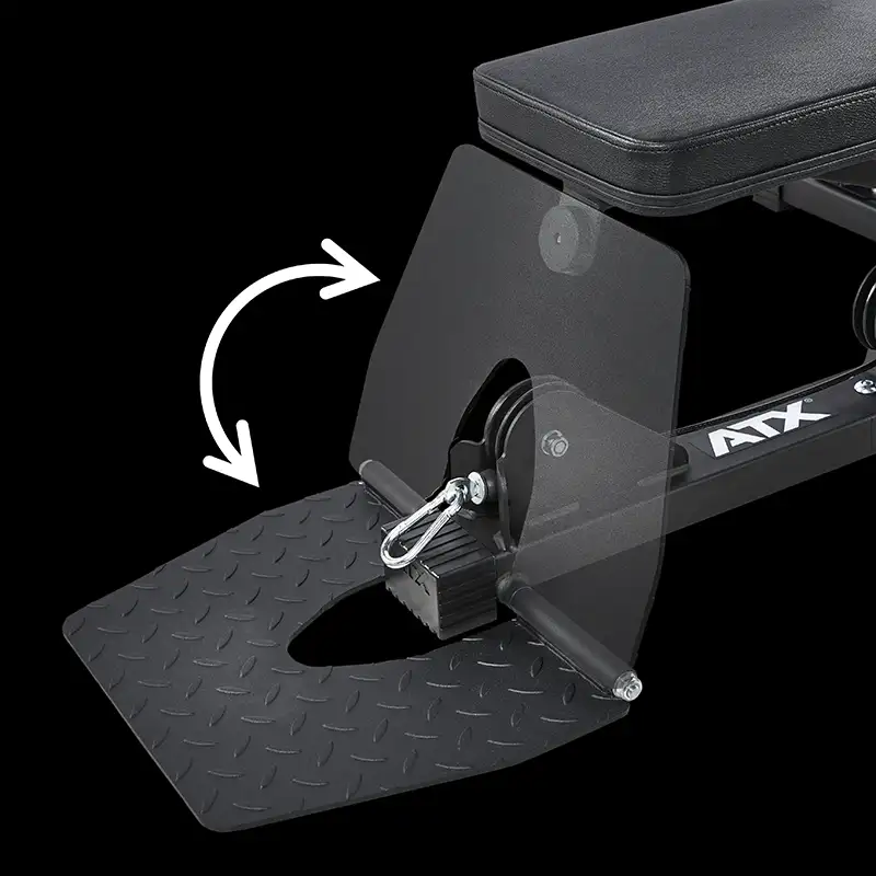 A close-up of a black gym bench with a textured, foldable footplate mid-adjustment, marked by a white arrow for its adjustable position. Ideal to pair with the ATX® Cable Lat Pull Down Machine.