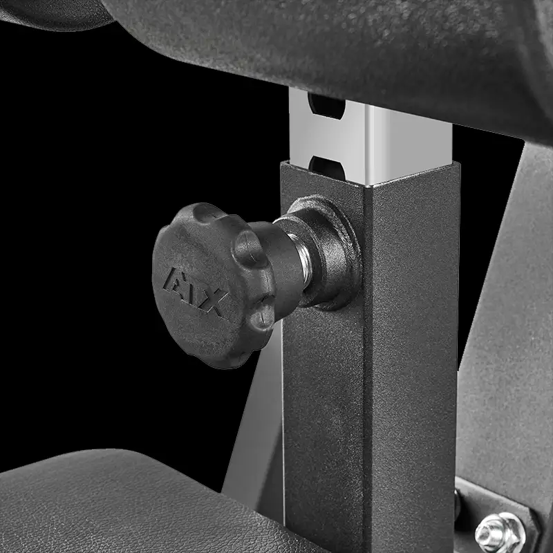 Close-up of a black knob labeled MAX on the ATX® Cable Lat Pull Down Machine, mounted to a metal frame with nearby padding, all against a black background.