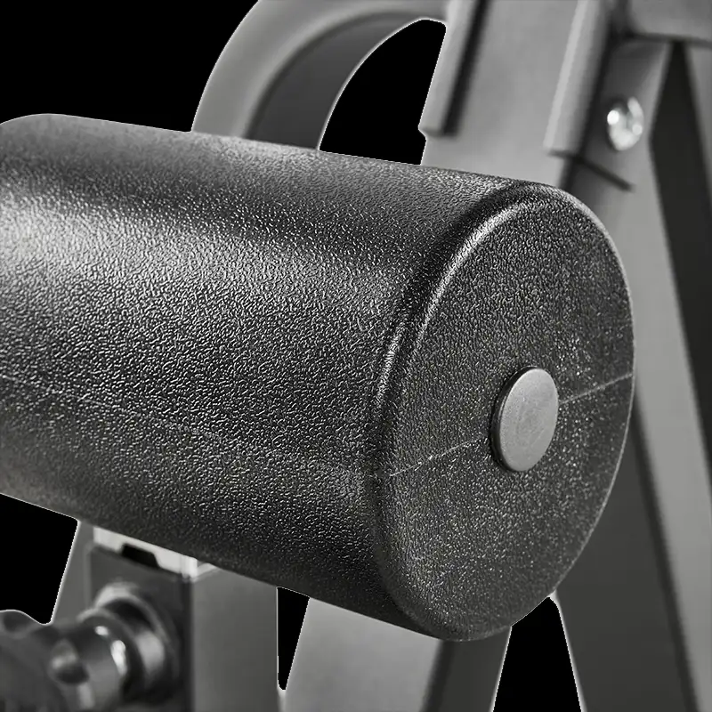 Close-up of a textured black cylindrical padded roller on the ATX® Cable Lat Pull Down Machine, with metal support bars and bolts visible in the background.