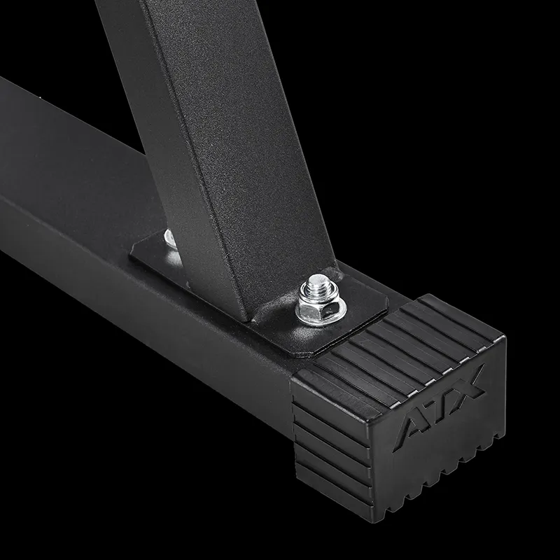 Close-up of a black metal frame from the ATX® Cable Lat Pull Down Machine, featuring bolts joining the vertical and horizontal bars. The ridged rubber end cap, embossed with ATX, is visible against a solid black background.