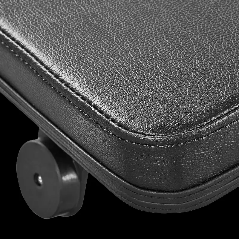 Close-up of a black, textured leather seat cushion with stitched edges on the ATX® Cable Lat Pull Down Machine, showing a plastic or metal wheel at the bottom left corner.