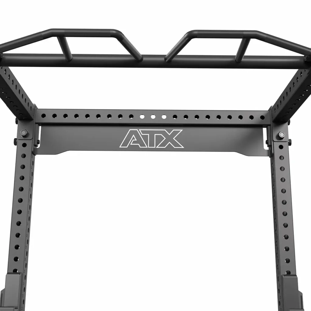 A close-up of the ATX® Power Rack 780 shows its steel structure with multiple pull-up bars and adjustable holes. The ATX logo is visible on the horizontal bar, and it has a black finish, perfect for strength training.