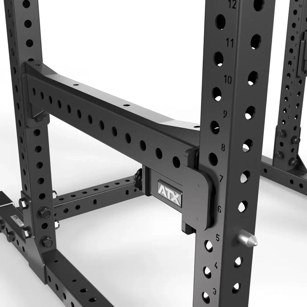 Close-up of the ATX® Power Rack 780, a black metal gym power rack featuring adjustable holes with labeled numbers for customization. The ATX logo is visible on a bracket.