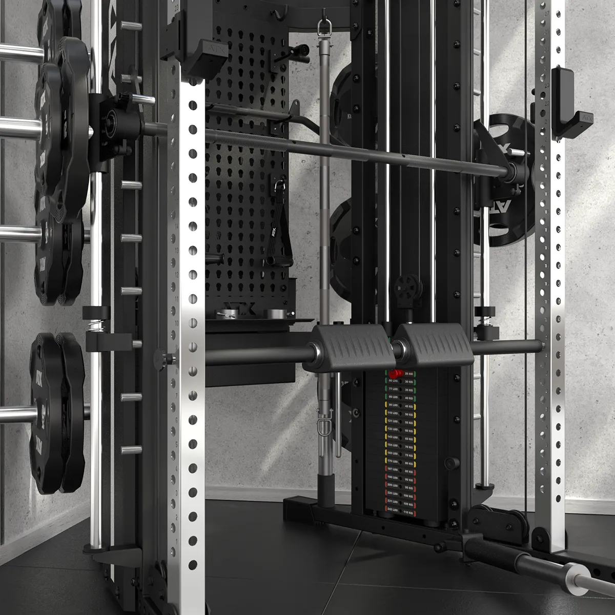 The ATX® Monster 2.0 All In One Trainer, featuring attached weight plates, a barbell, padded supports, and an adjustable weight stack, is set in a corner with light gray walls and a black rubber floor.