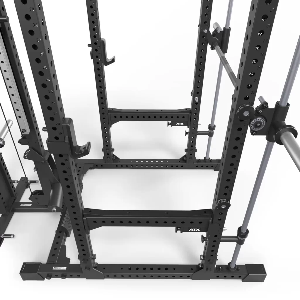 The ATX® Power Rack is a black metal weightlifting station featuring a Smith and pulley system, adjustable holes for safety bars and attachments, and two vertical support beams with visible ATX branding.