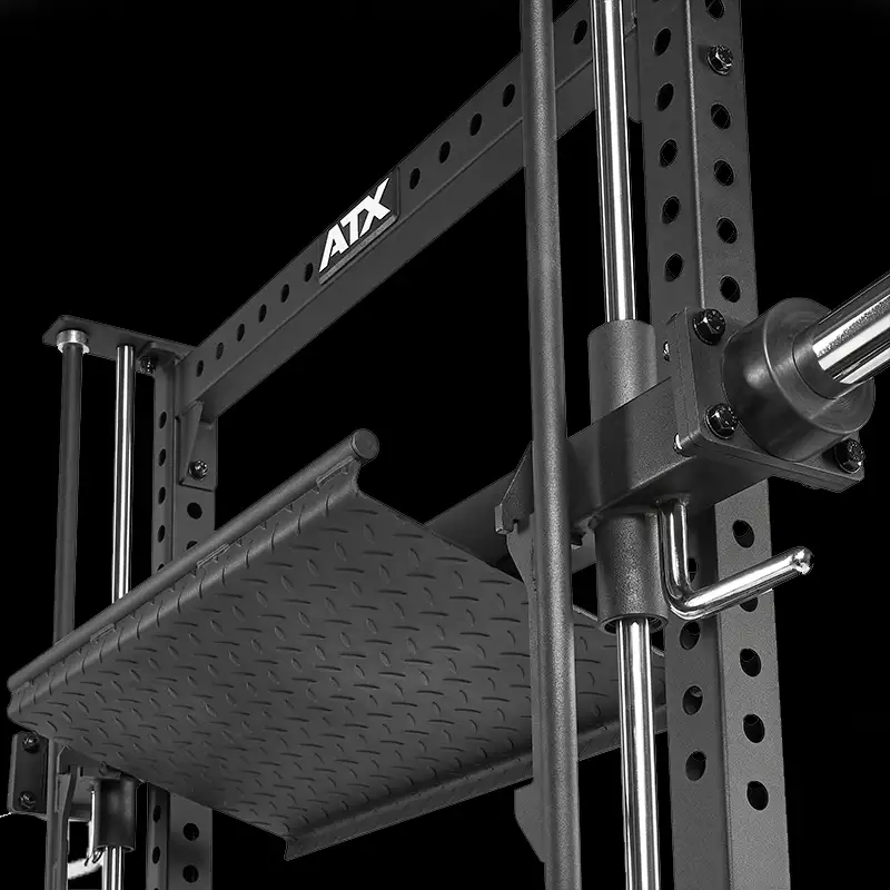 Close-up of the ATX® Vertical Leg Press, a black metal power rack with safety bars and a textured steel platform for weightlifting or vertical leg press exercises, set against a black background.
