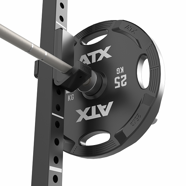 Close-up of a 25 kg weight plate mounted on a barbell within a squat rack. The weight plate and rack are black, with the brand logo ATX visible. The barbell is secured with clamps attached to the rack.