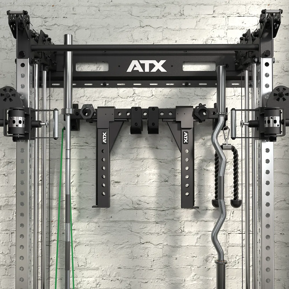 A close-up of the ATX Half Rack with Cable Crossover, mounted against a white brick wall, featuring pulleys, bars, grips, a rope attachment, and multiple handles designed for versatile weight training exercises.