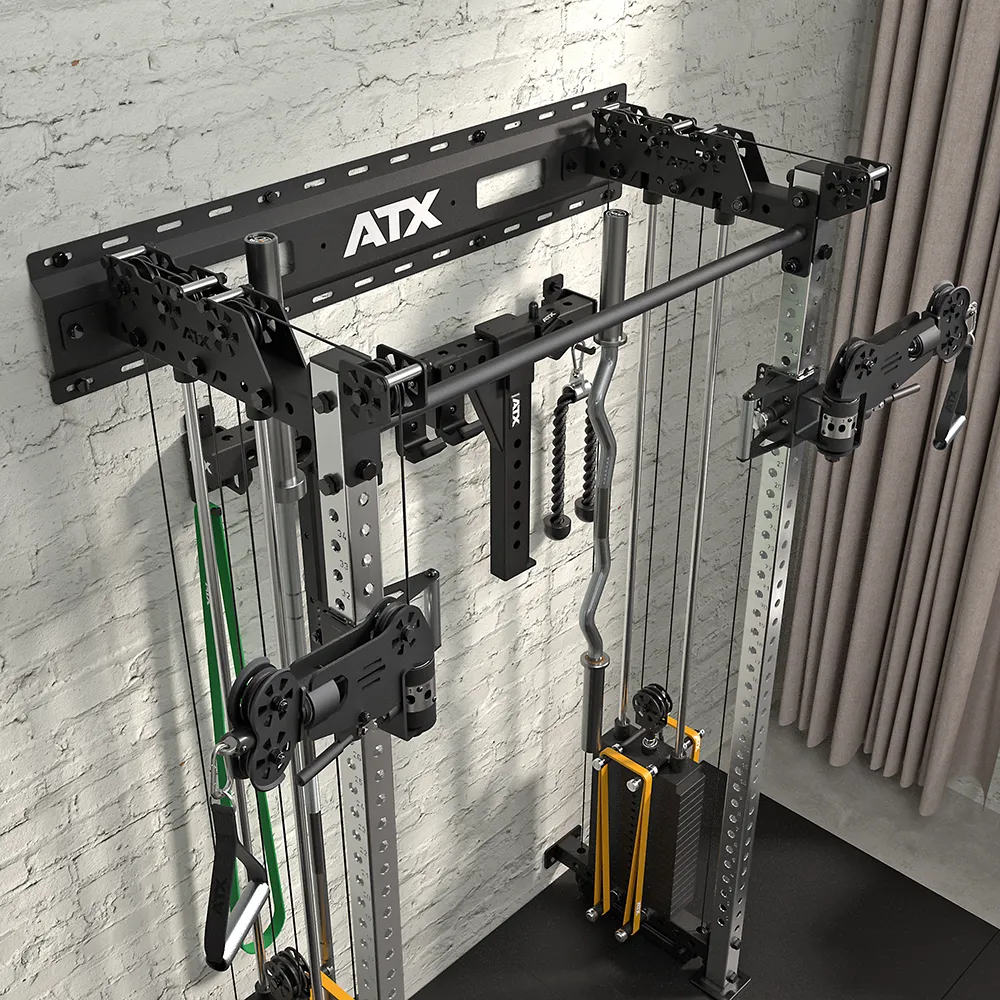 The ATX Half Rack with Cable Crossover is set against a white brick wall, showing the ATX logo above and weight stacks below. It comes with multiple attachments and resistance bands, with beige curtains partly seen to the right.