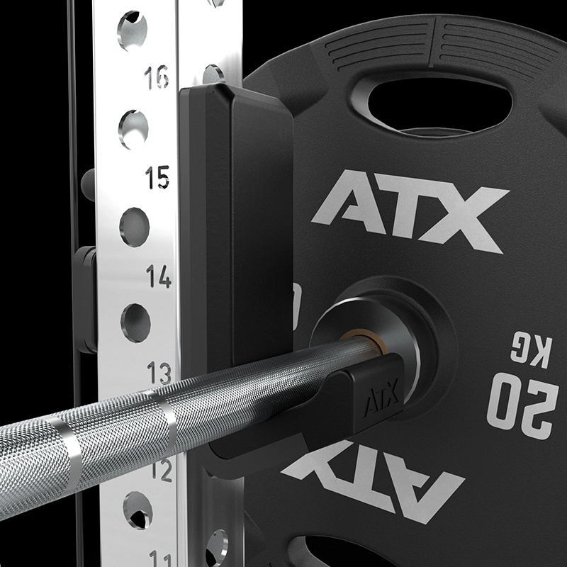 Close-up of a 20 kg ATX weight plate on a barbell mounted to the ATX Half Rack with Cable Crossover, featuring numbered height markings and a black safety catch.