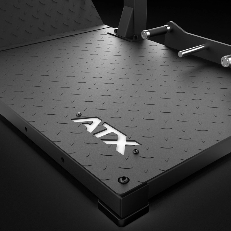 Close-up of the ATX® Pendulum Squat Machine’s black, diamond plate platform with ATX cutout. Two cylindrical handles are attached on the right, and lighting emphasizes its rugged metallic finish.