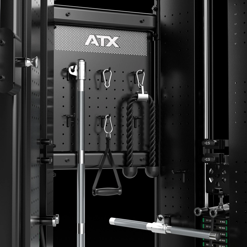 Close-up of a black gym equipment storage rack with an ATX logo, holding various workout attachments including a bar, handle, rope, clips, and carabiners, all neatly organized against a perforated metal background.