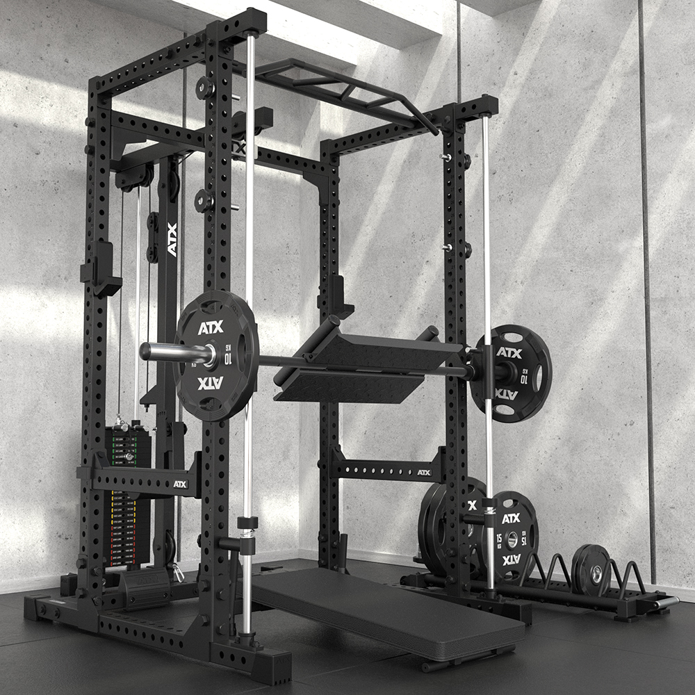 A black power rack gym station with a barbell, weight plates, cable machine, pull-up bar, and various attachments, set up in a modern, minimalist room with concrete walls and a rubber floor.