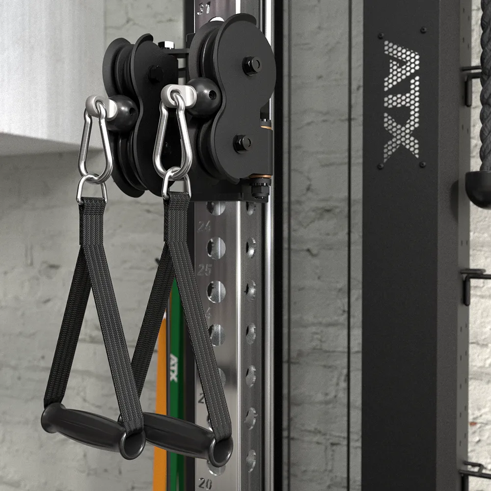 Close-up of the ATX® Single Cable Station - Wall Mounted with two black handles attached. The gym machine is set against a brick wall, and part of the device displays the ATX branding.