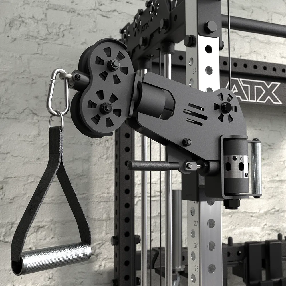 Close-up of a black adjustable pulley system with a handle attachment mounted on a metal gym frame, set against a white brick wall background.