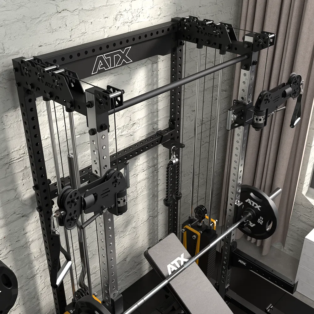 A multifunctional ATX home gym machine with adjustable pulleys, weight plates, and a bench is set up against a brick wall near a window with curtains.
