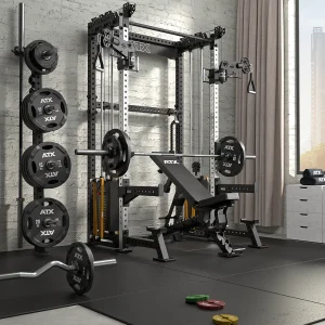 A modern home gym with a power rack, bench press, weight plates, barbells, cable machine, and gym accessories, set on rubber flooring near a window with natural light and a curtain.