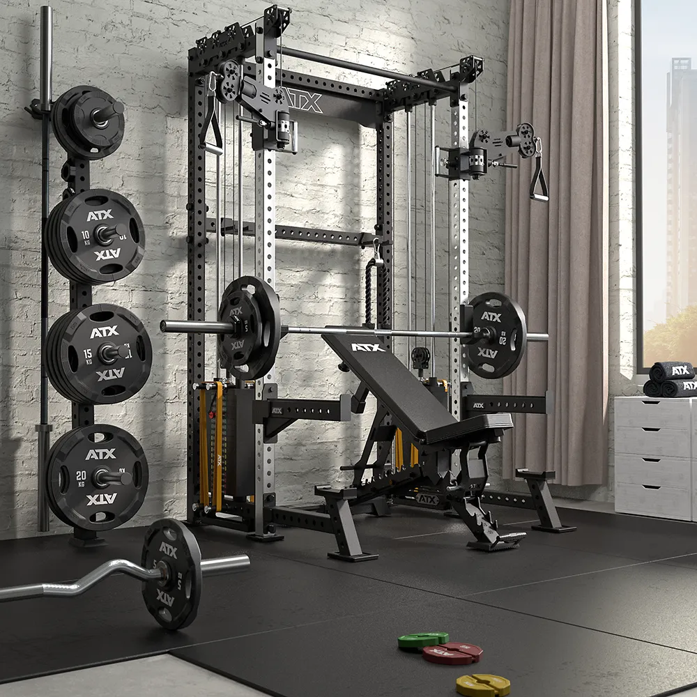 A modern home gym with a power rack, bench press, weight plates, barbells, cable machine, and gym accessories, set on rubber flooring near a window with natural light and a curtain.