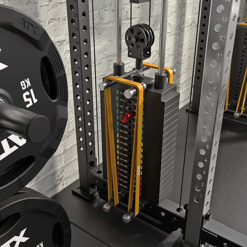 A close-up of a gym weight stack with a pin selector, attached to a cable machine. Nearby, weight plates marked 15 KG are visible. The setup is next to a brick wall and metallic gym equipment.