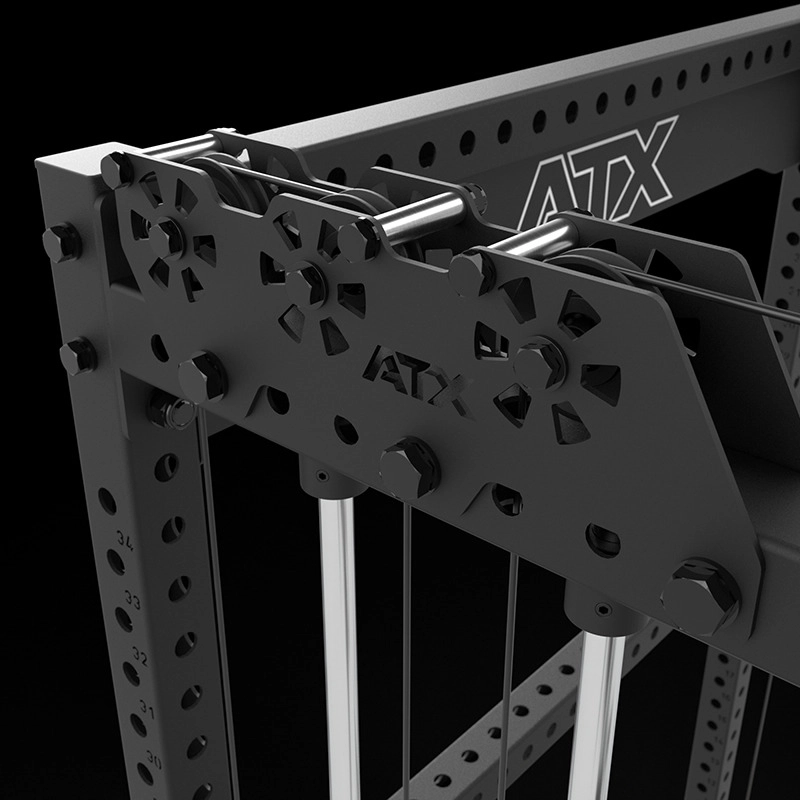 Close-up of a black metal ATX-branded cable pulley system, showing adjustable holes, cables, and bolts, part of a gym or fitness machine against a dark background.