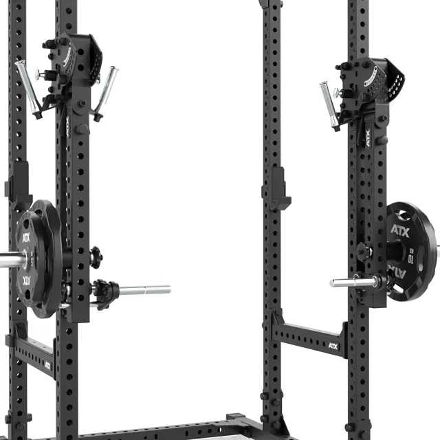 A close-up view of a black power rack with adjustable arms and loaded weight plates on both sides, designed for weightlifting and strength training exercises.