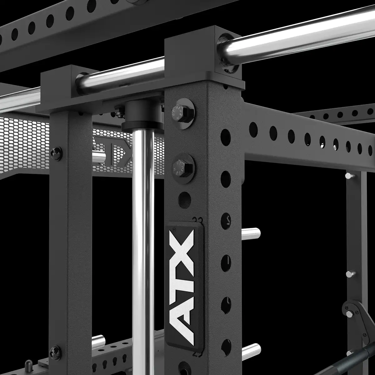 Close-up view of a black metal gym power rack with multiple holes for attachments, chrome support bars, and an ATX logo plate on the frame. The background is black and there is mesh paneling visible.