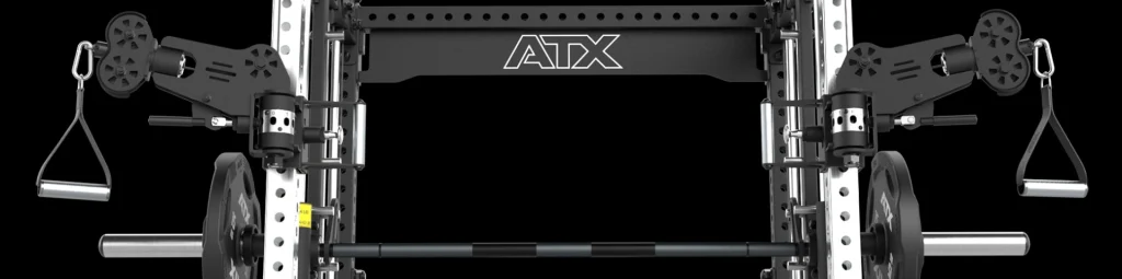 Close-up view of an ATX-branded gym machine with a black frame, two cable pulley systems with handles on each side, and a barbell with weight plates mounted at the bottom.