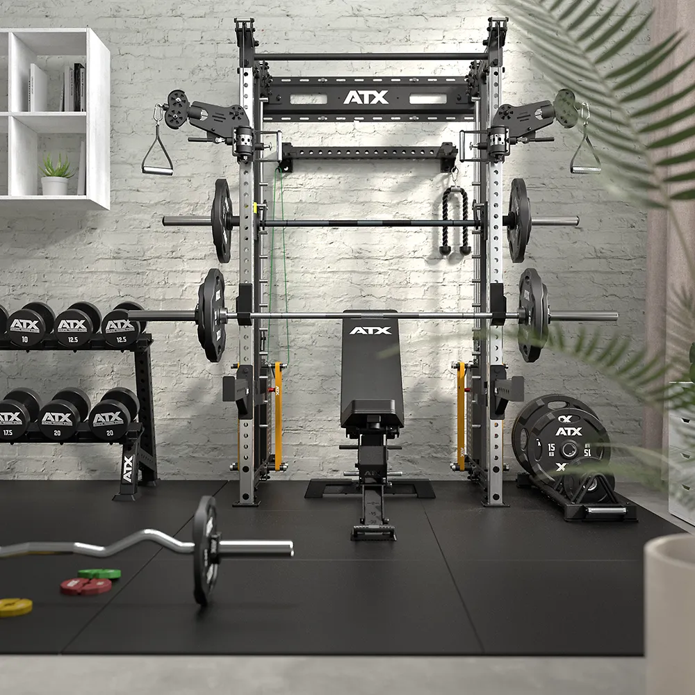 Home gym featuring the ATX® Squat Rack with Cables, a weight bench, barbells, weight plates, and dumbbells on racks. Equipment is neatly organized against a white brick wall with a plant in the foreground.