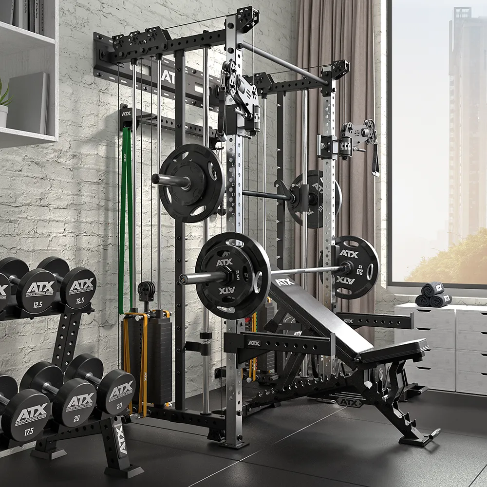 A home gym featuring the ATX® Squat Rack with Cables, weight plates, barbells, an adjustable bench, resistance bands, and a dumbbell rack—all set on black flooring by a large window overlooking stunning city views.