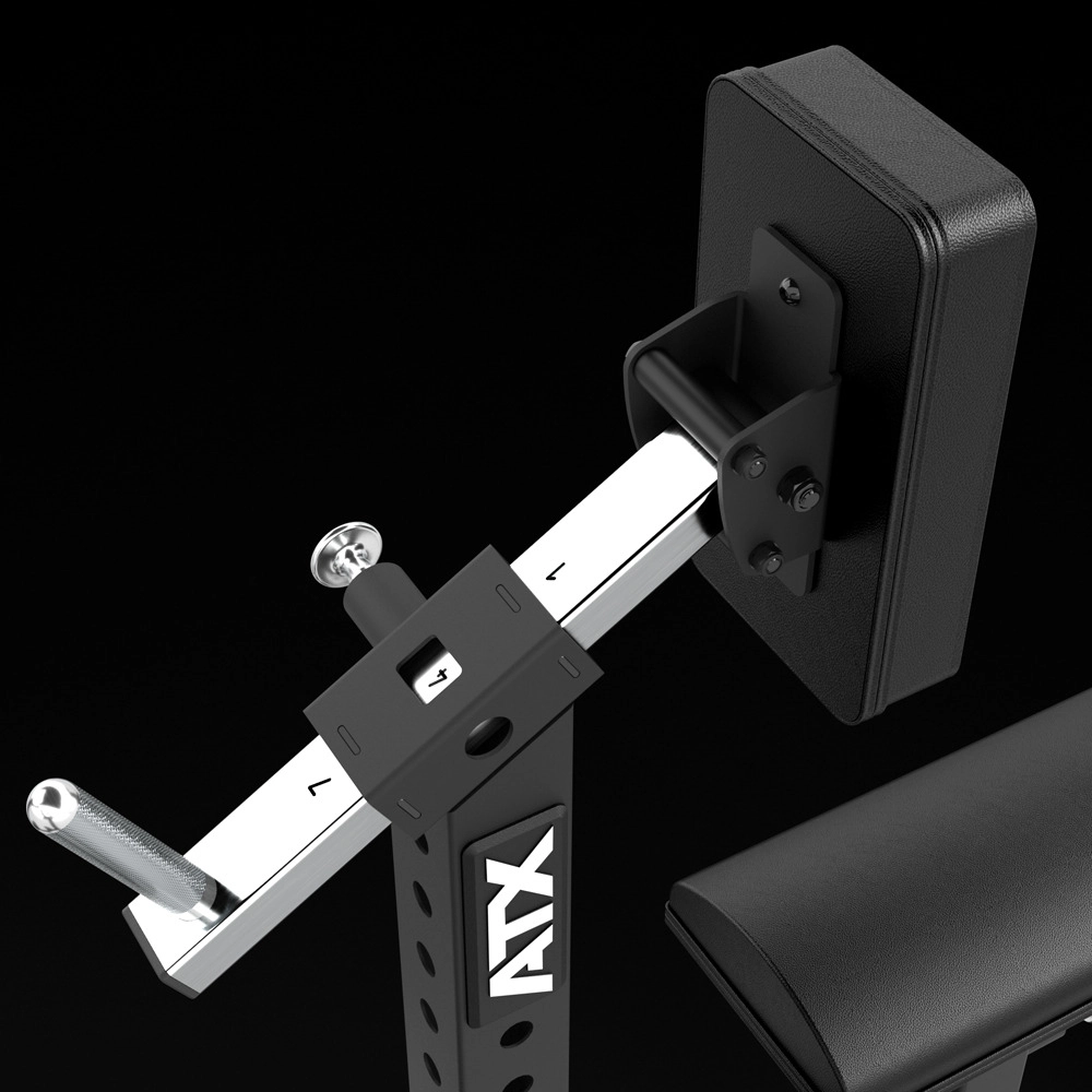 Close-up of a black and silver adjustable gym bench attachment with padded support, metal pegs, and “ATX” logo on the frame, set against a solid black background.