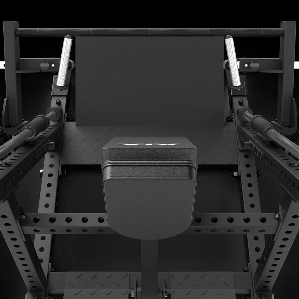 Close-up view of a black gym leg press machine, showing the padded seat, footplate, handles, and metal frame with multiple holes for adjustable settings.