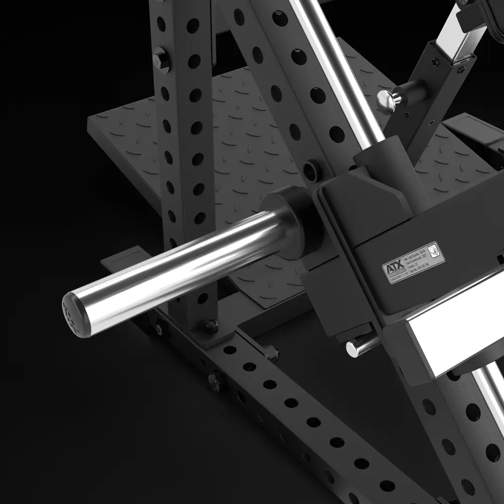 Close-up of a metal fitness machine attachment with a chrome bar and black framework, featuring adjustable holes and a textured footplate on a black background.