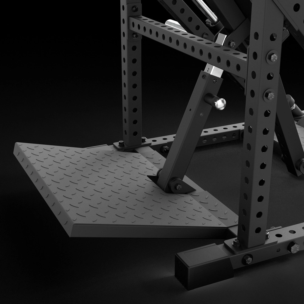 Close-up of a black metal gym leg press machine with a textured footplate and sturdy, perforated steel frame on a dark background.