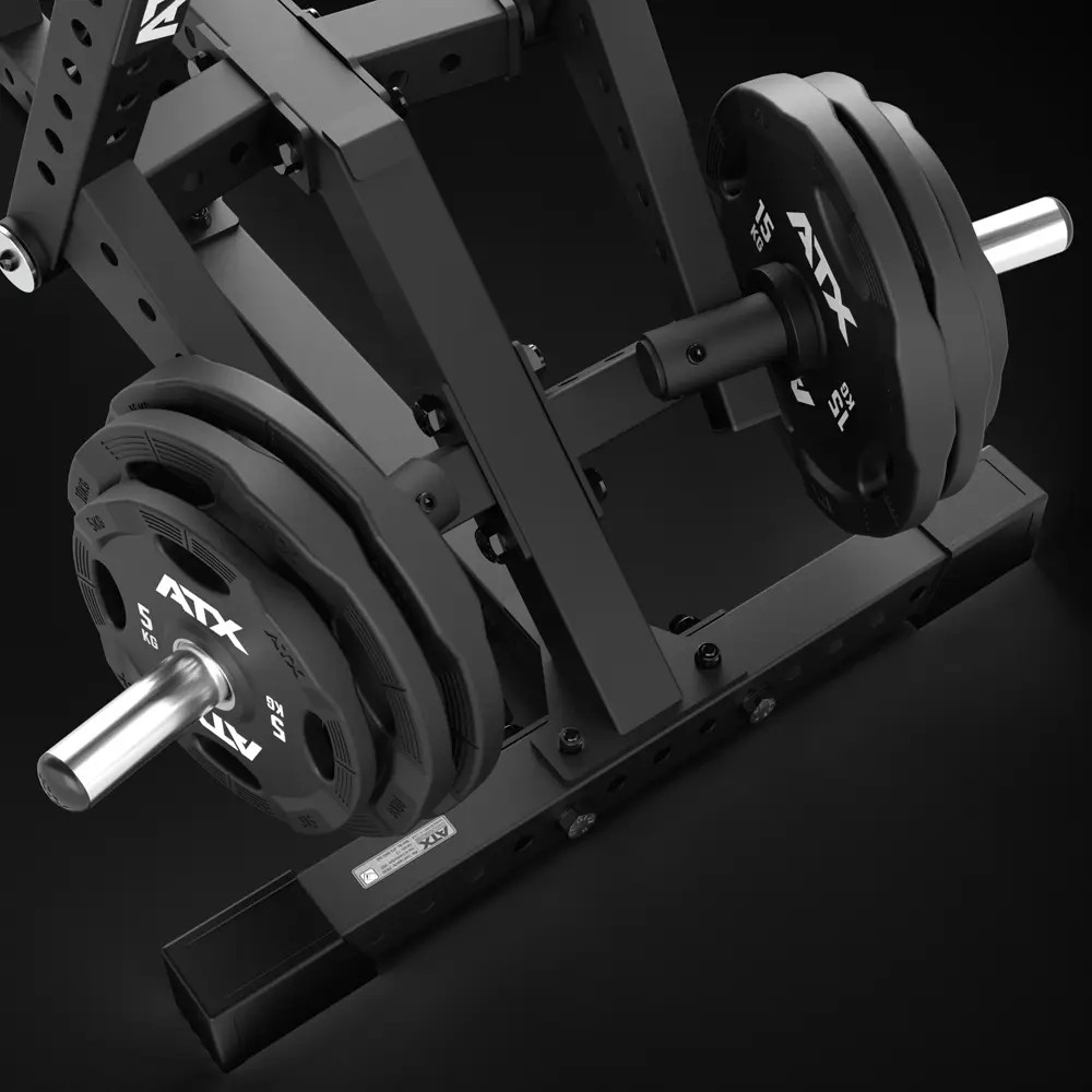 A close-up view of a black gym machine with multiple weighted plates labeled ATX stacked on metal rods, set against a dark background.