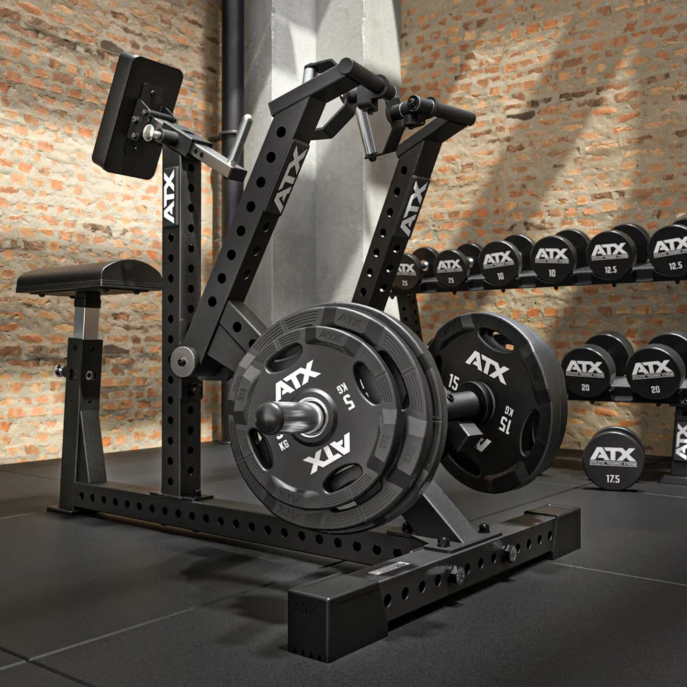 A black ATX gym machine with weight plates is positioned on a black mat in a gym with exposed brick walls. Dumbbells are neatly arranged on a rack in the background.