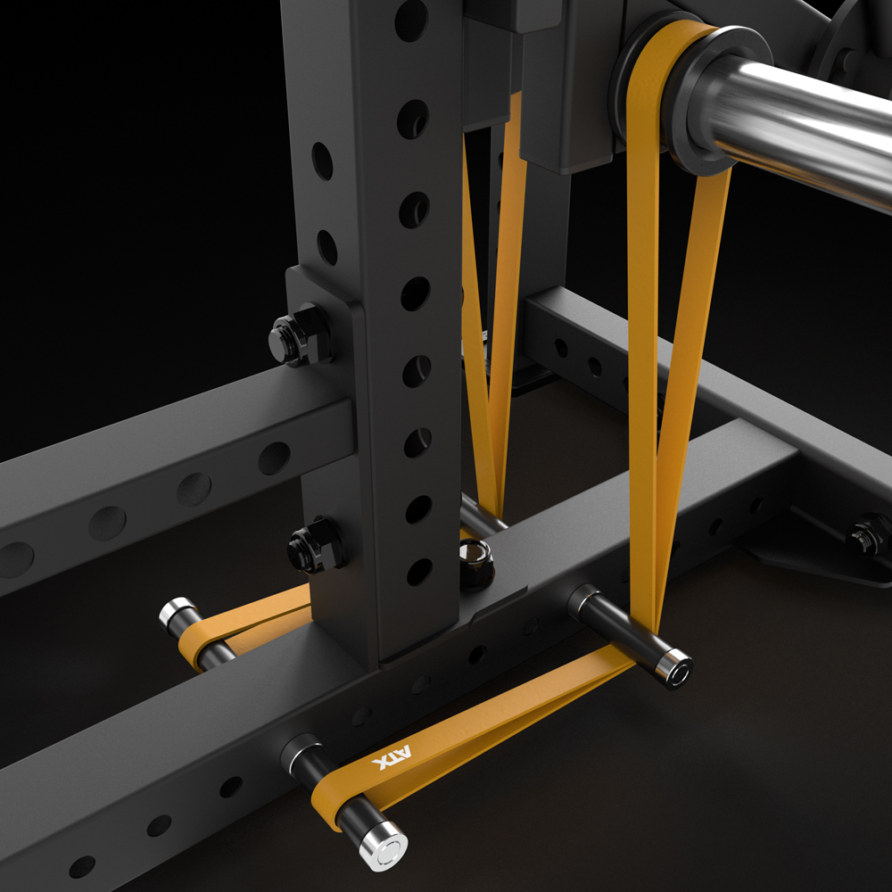 Close-up of a power rack with an orange resistance band on metal pegs and a barbell, demonstrating band setup for strength training beside the ATX® Bicep Blaster Preacher Curl Machine (Copy).