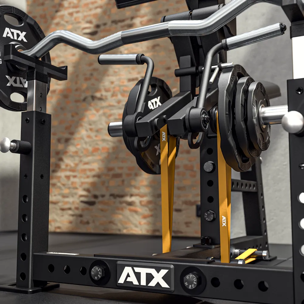 Close-up of a black ATX squat rack with loaded weights and a curved barbell. Beside it stands the ATX® Bicep Blaster Preacher Curl Machine, all set against a brick wall with yellow safety arms enhancing the rack's design.