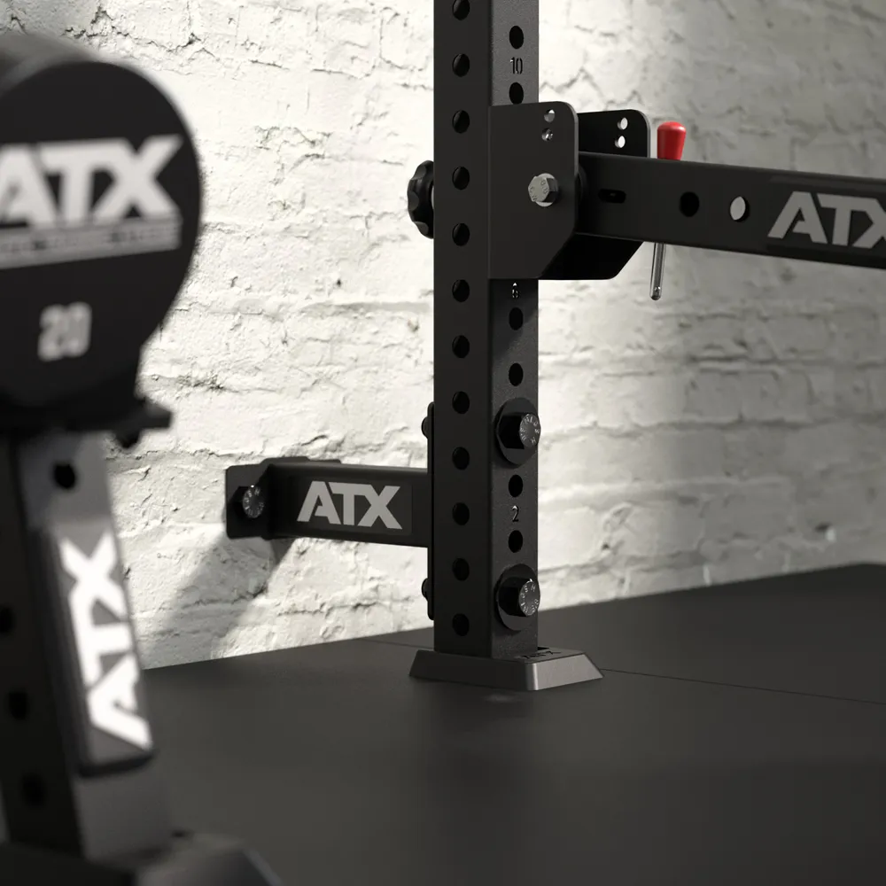 Wall-mounted ATX gym squat rack rig with adjustable safety bar attachments.