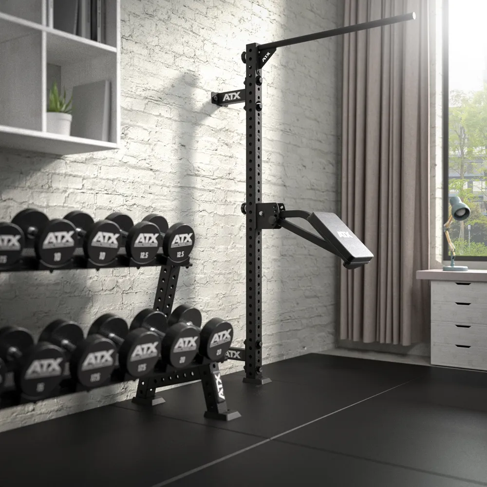 Wall-mounted squat rack with an attached pull-up bar and weight bench, next to a two-tier rack holding various ATX dumbbells.